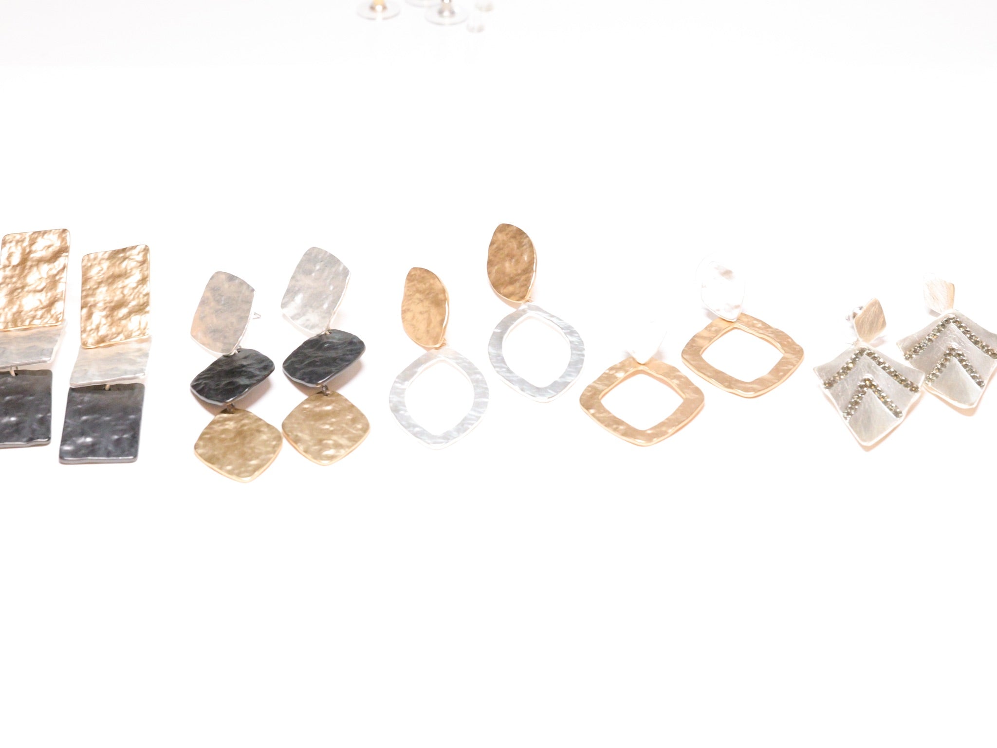Geometric hammered metal statement earrings in gold, silver, and mixed tones with modern artisan design
