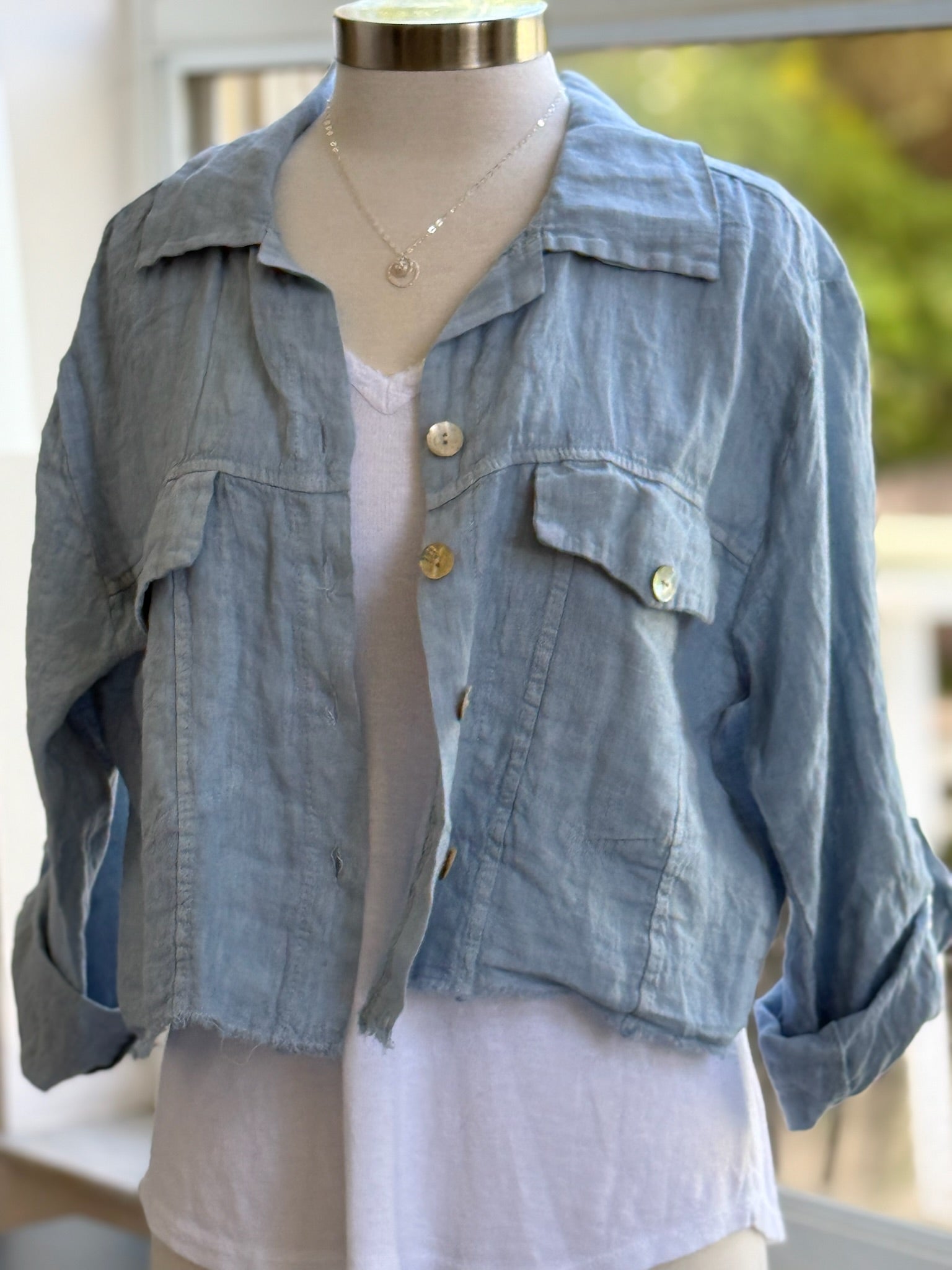 Light blue linen button front cropped jacket with chest pockets and raw hem from Ardor Boutique