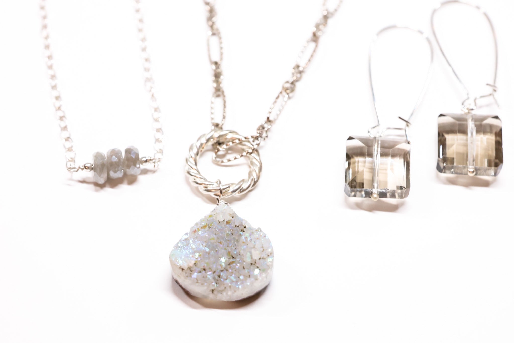 Luminous Neutrals jewelry featuring moonstone, druzy pendant necklace, smoky quartz earrings, and faceted gemstone accents