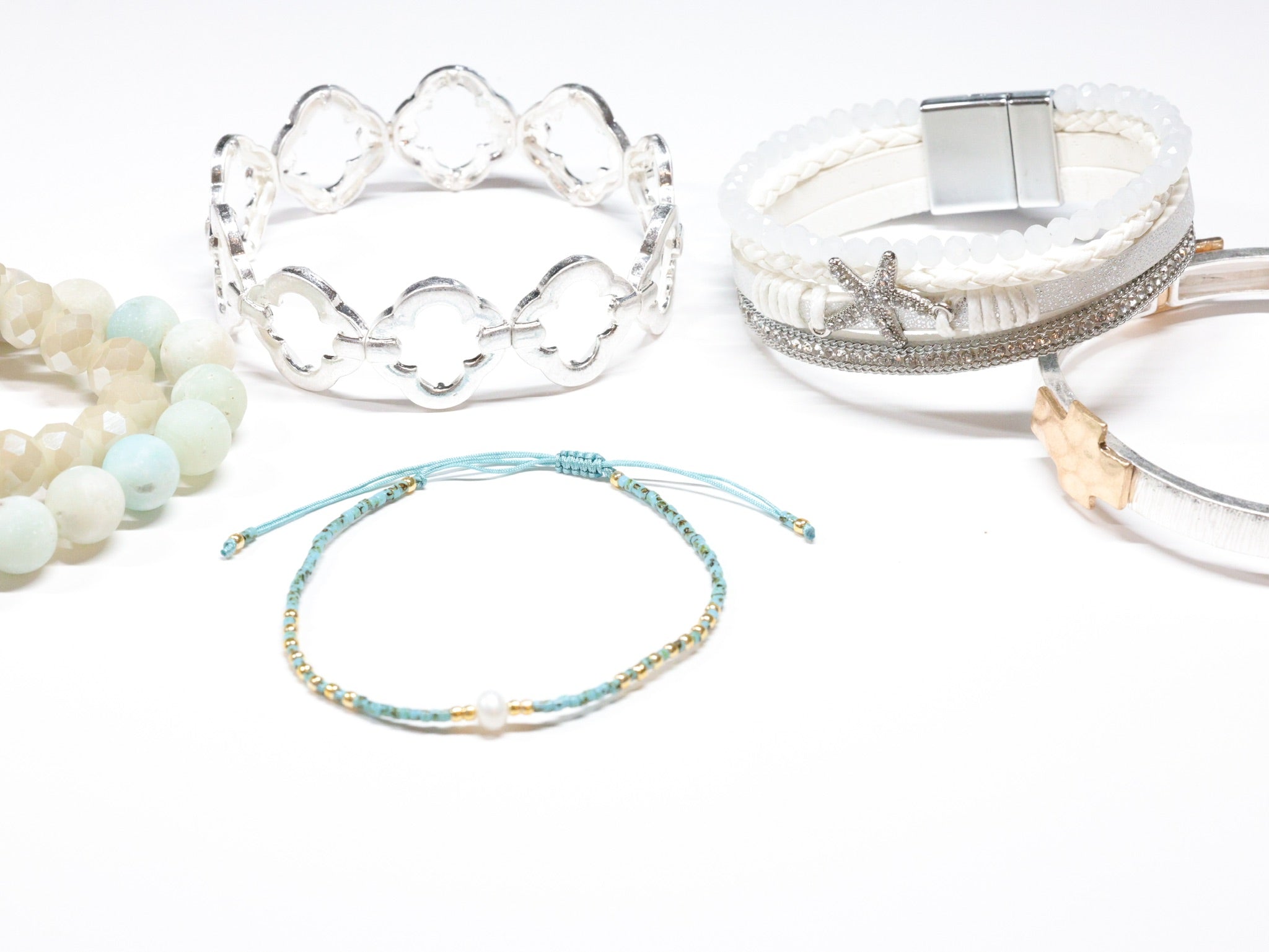 Assorted beaded and silver cuff bracelets with starfish and pearl details from Ardor Boutique