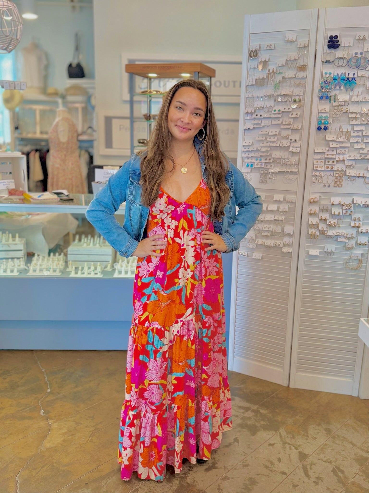 Bright floral maxi dress with orange and pink tropical print styled with denim jacket from Ardor Boutique