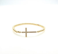 Gold beaded cross bracelet. 