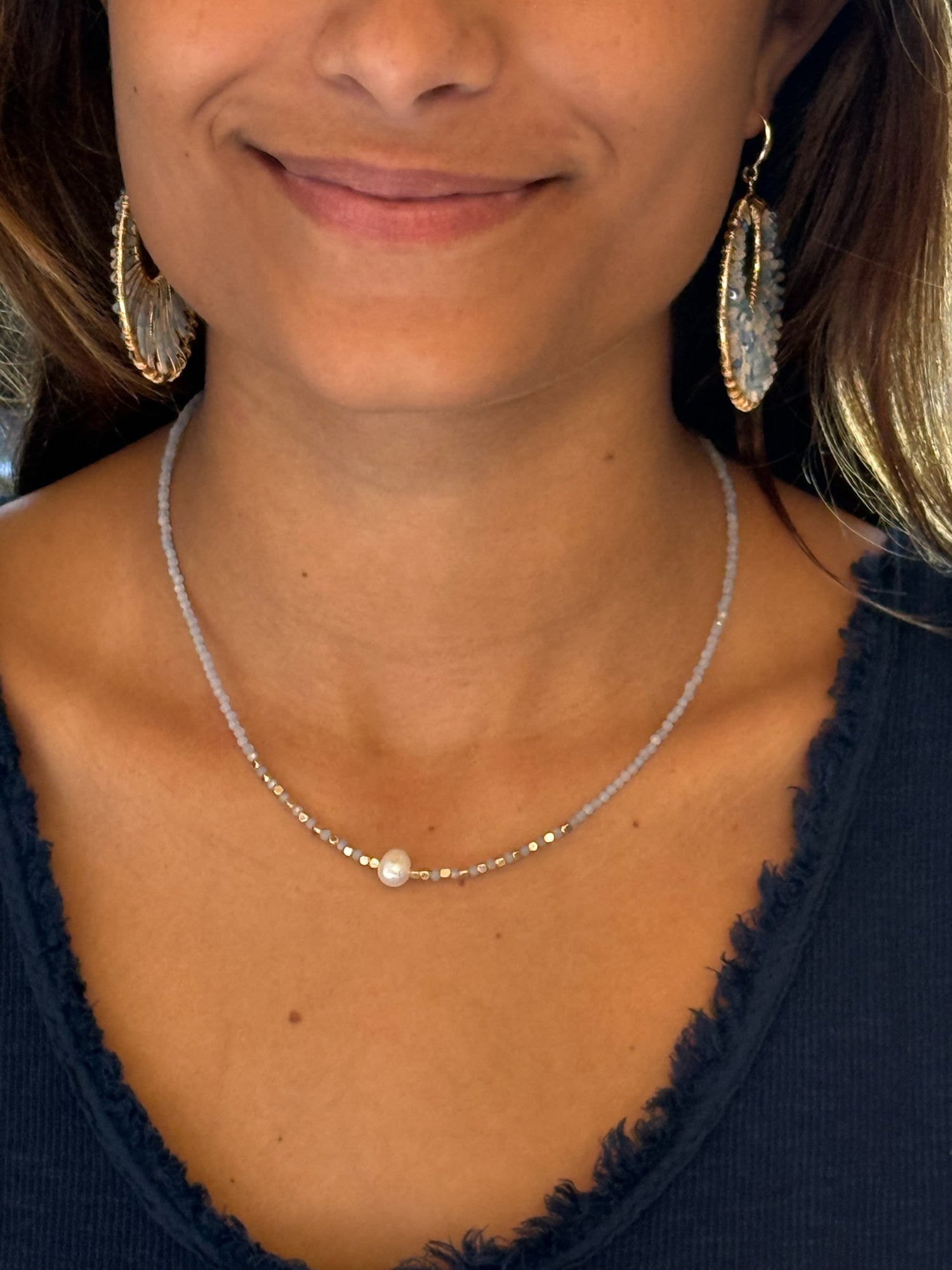 blue beaded necklace with a single pearl