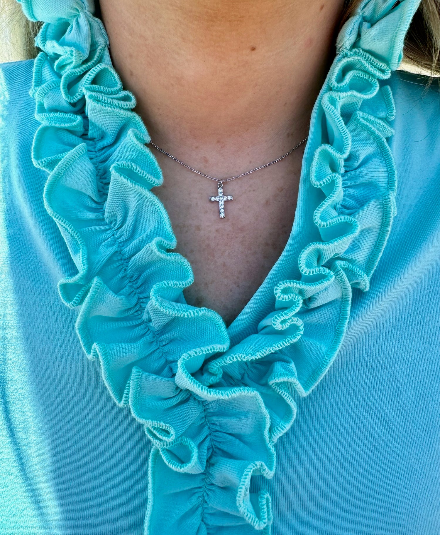 Addie Cross necklace in silver shown on model