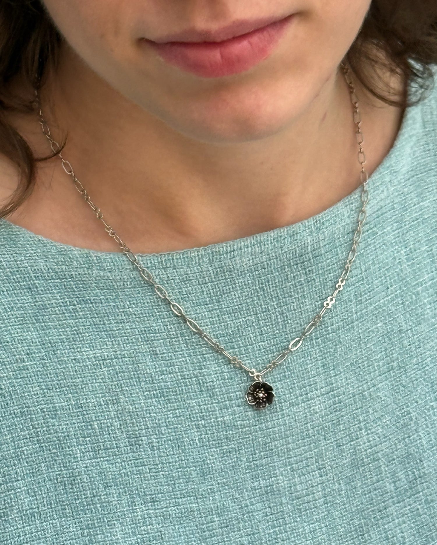 Close-up of a silver necklace with a five-petal flower pendant and dual-link chain – Five Fold Bloom Necklace in antiqued silver