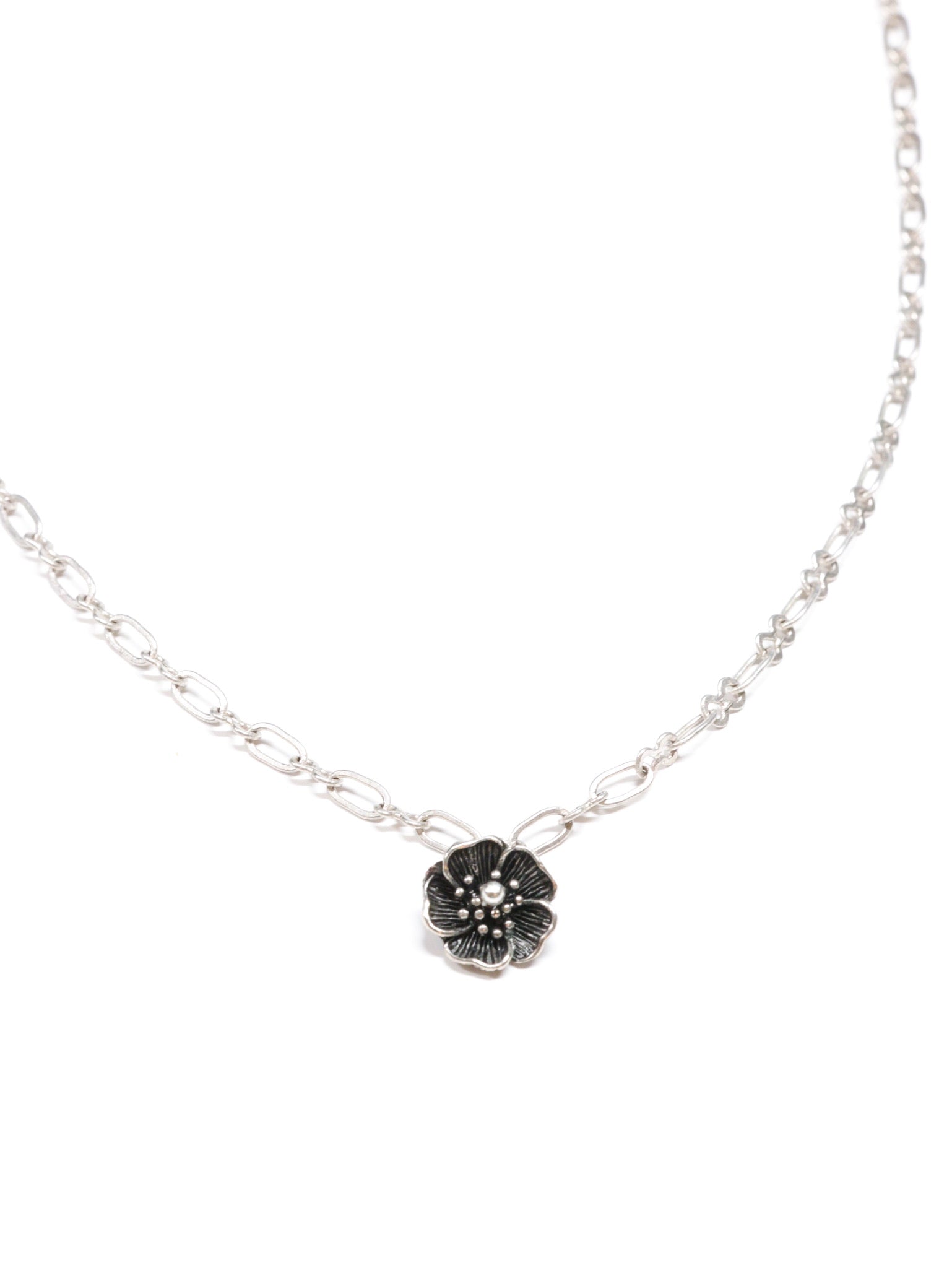Close-up of a silver necklace with a five-petal flower pendant and dual-link chain – Five Fold Bloom Necklace in antiqued silver