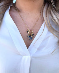 blue gold plated Quinn necklace with charms on model. 