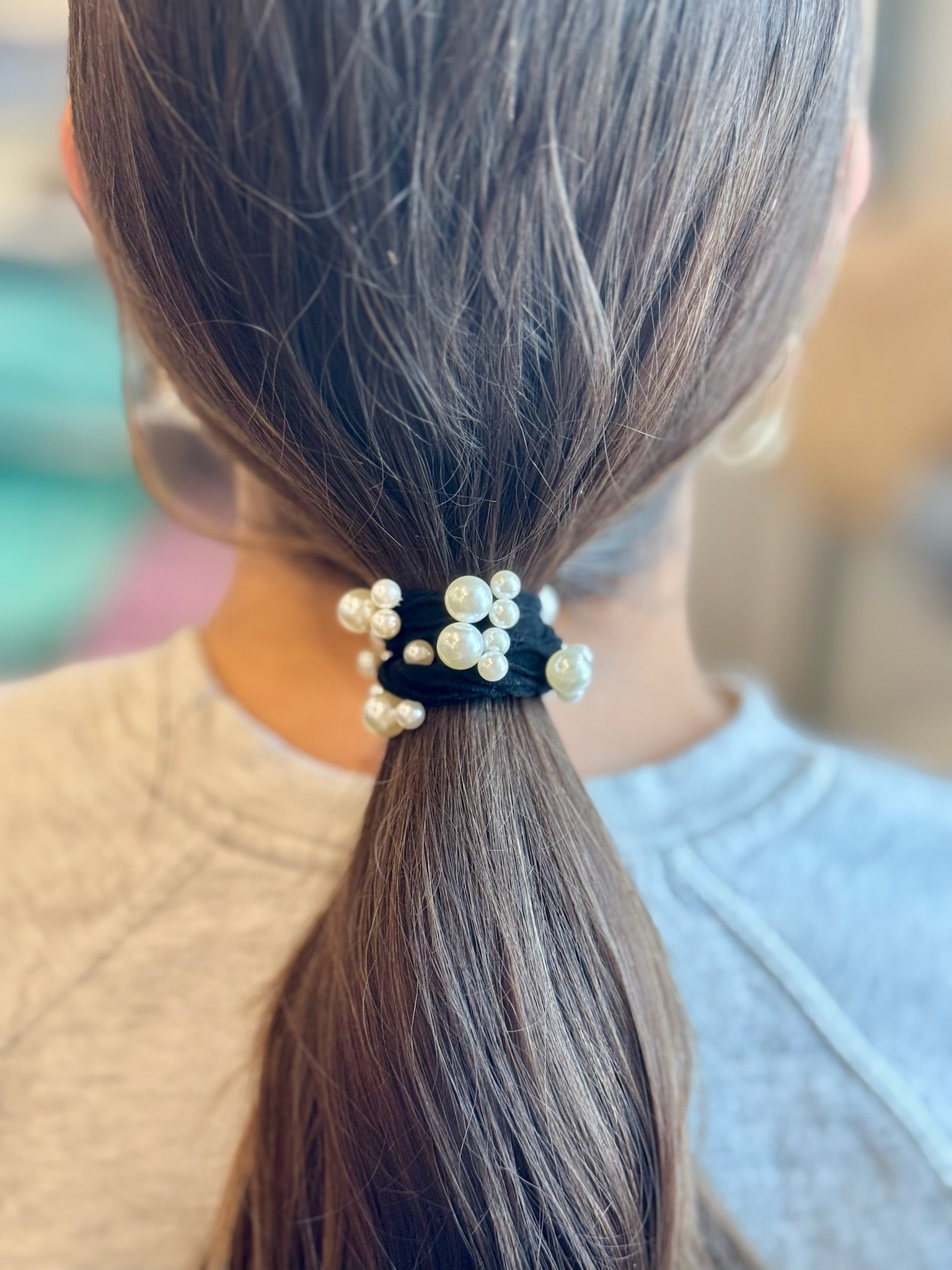 Pearl hair tie on a ponytail with a blurred background