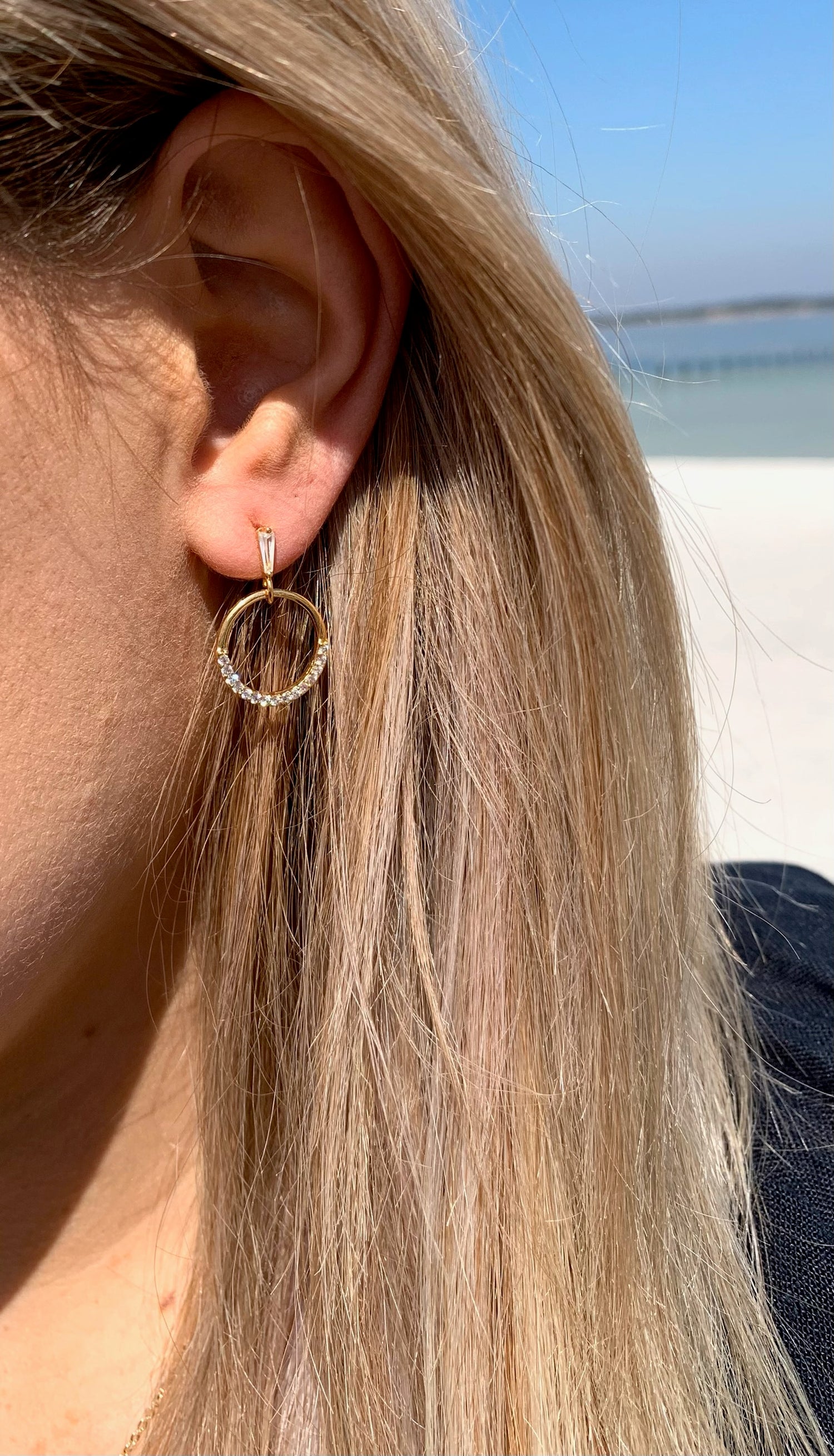 Sage sparkly earrings in gold on model.