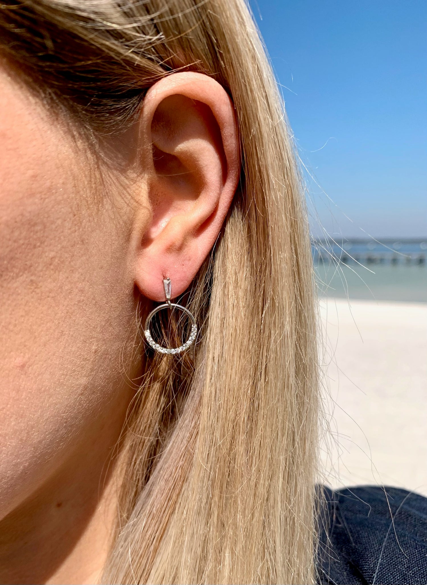 Sage sparkly earring in silver on model.