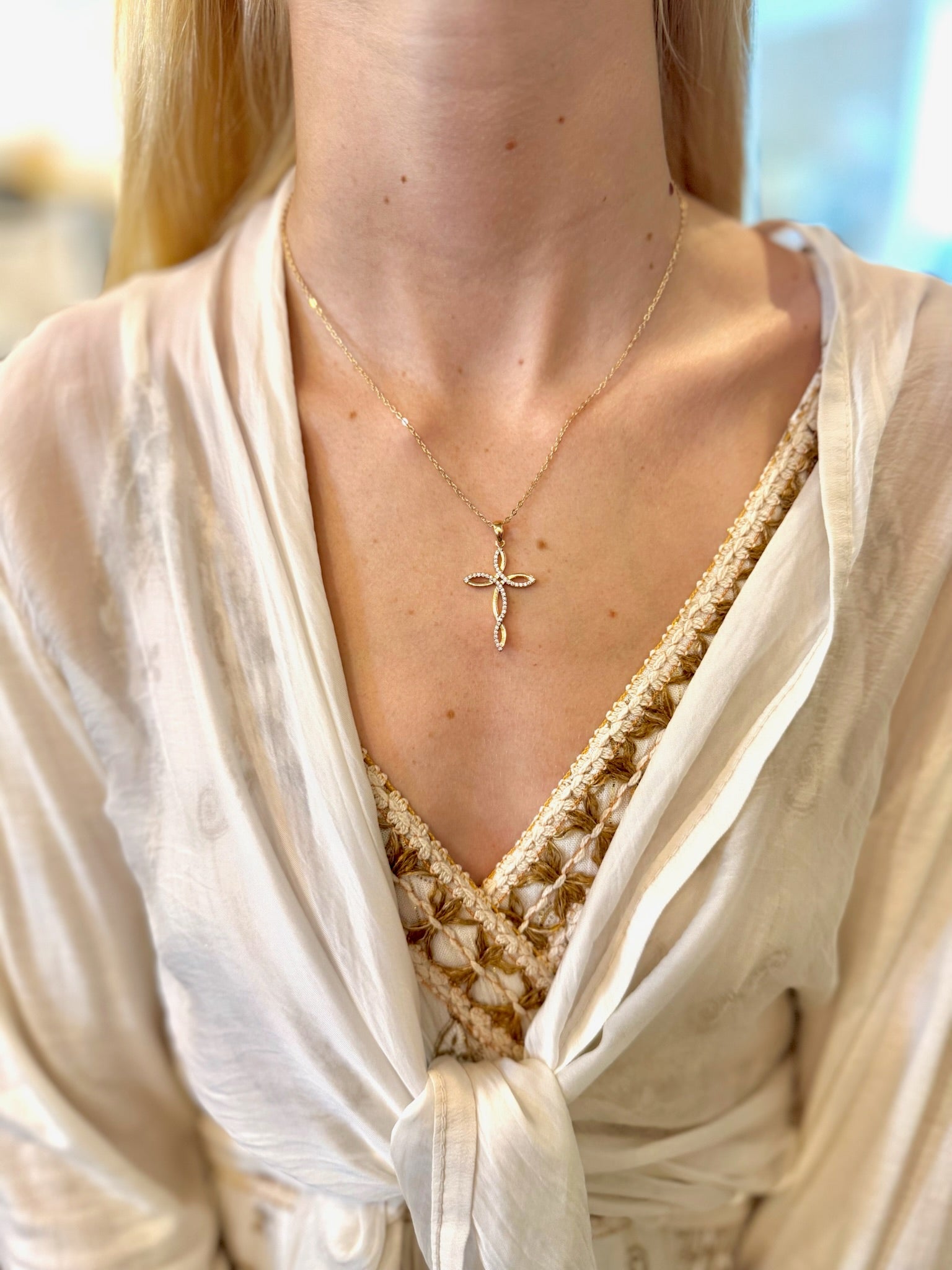 Gold Claire Cross Necklace with a delicate twisted cross pendant on a 19-inch chain.