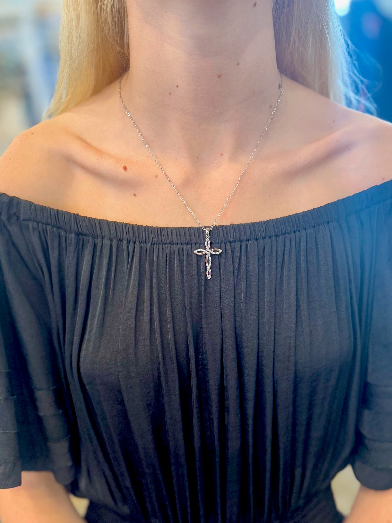Silver Claire Cross Necklace with a delicate twisted cross pendant on a 19-inch chain.