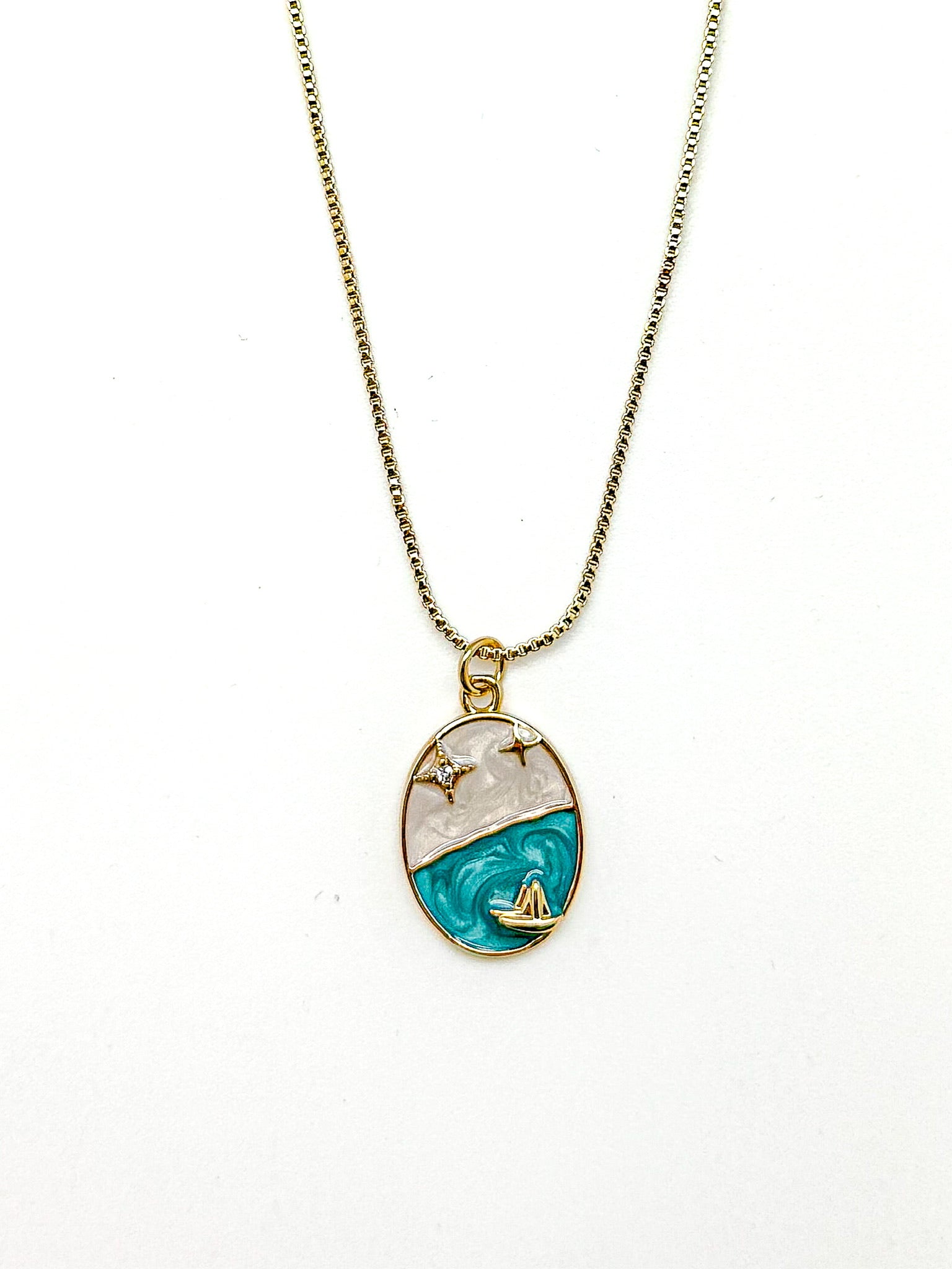 Marina Pendant Necklace with cubic zirconia star accents and golden sailboat on turquoise enamel wave.
