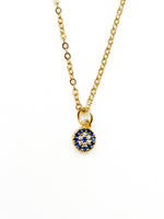 Gold necklace with a blue gemstone pendant on a white background