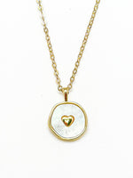Necklace with a gold chain and pendant featuring a gold heart design on a white background