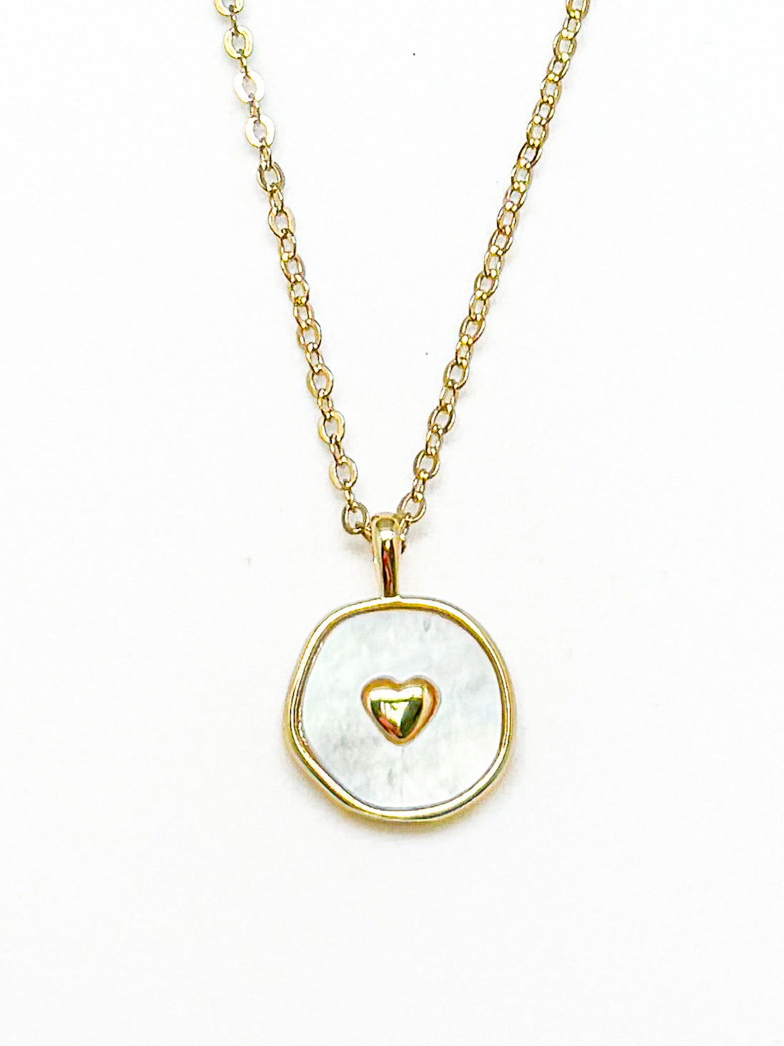 Necklace with a gold chain and pendant featuring a gold heart design on a white background