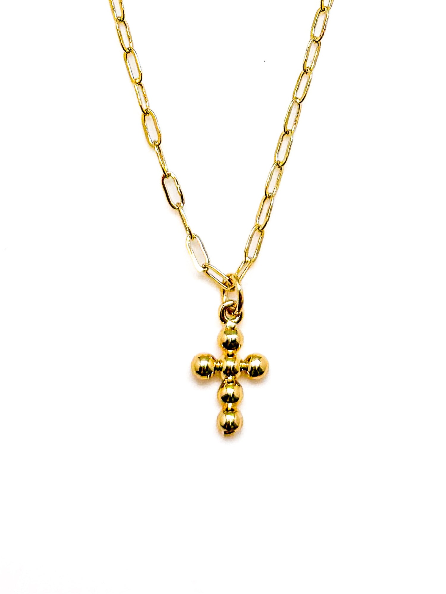 Gold necklace with a small cross pendant on a white background