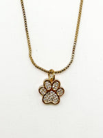 Gold necklace with a paw-shaped pendant on a white background