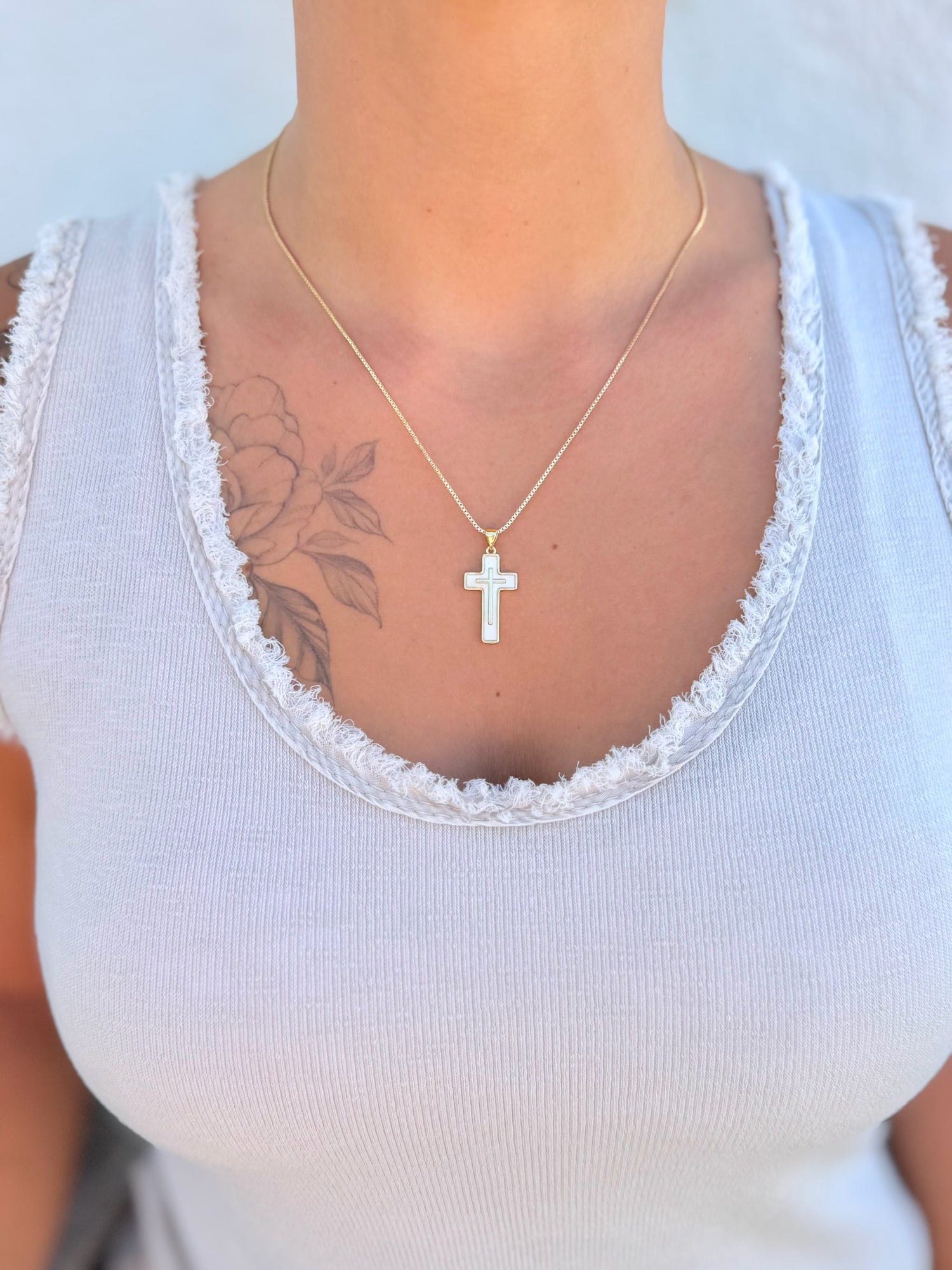 Perla Cross Necklace with gold chain and mother-of-pearl cross pendant being worn.