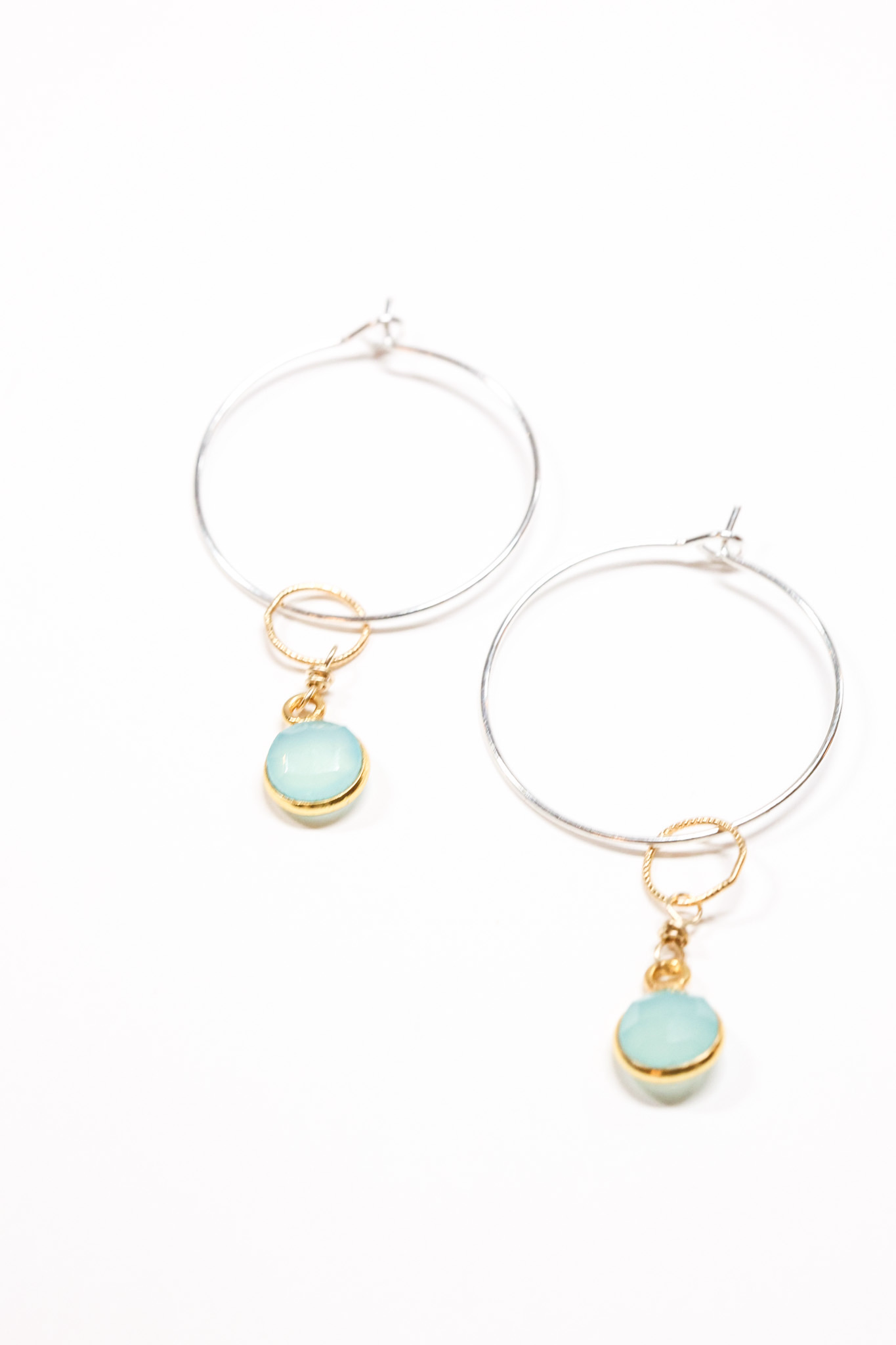 Camila 2 tone long aqua drop earring on flat lay.