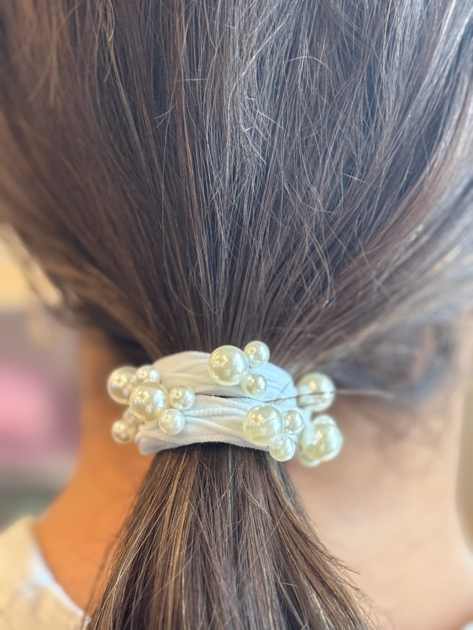 Hair tie with pearls wrapped around a ponytail