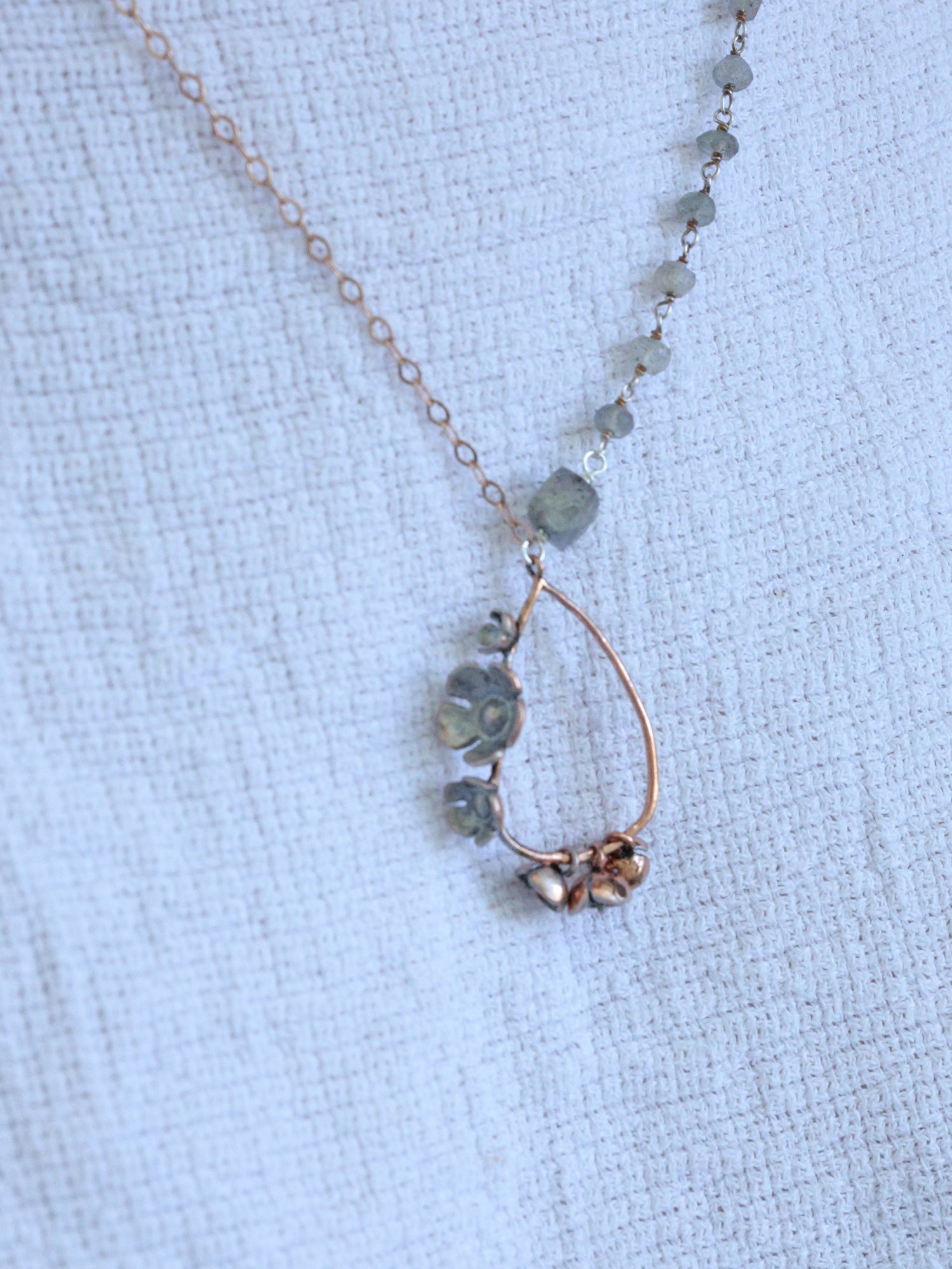 Rose gold teardrop necklace with labradorite gemstones and asymmetrical chain, handcrafted by Nina Halls for Ardor Boutique.