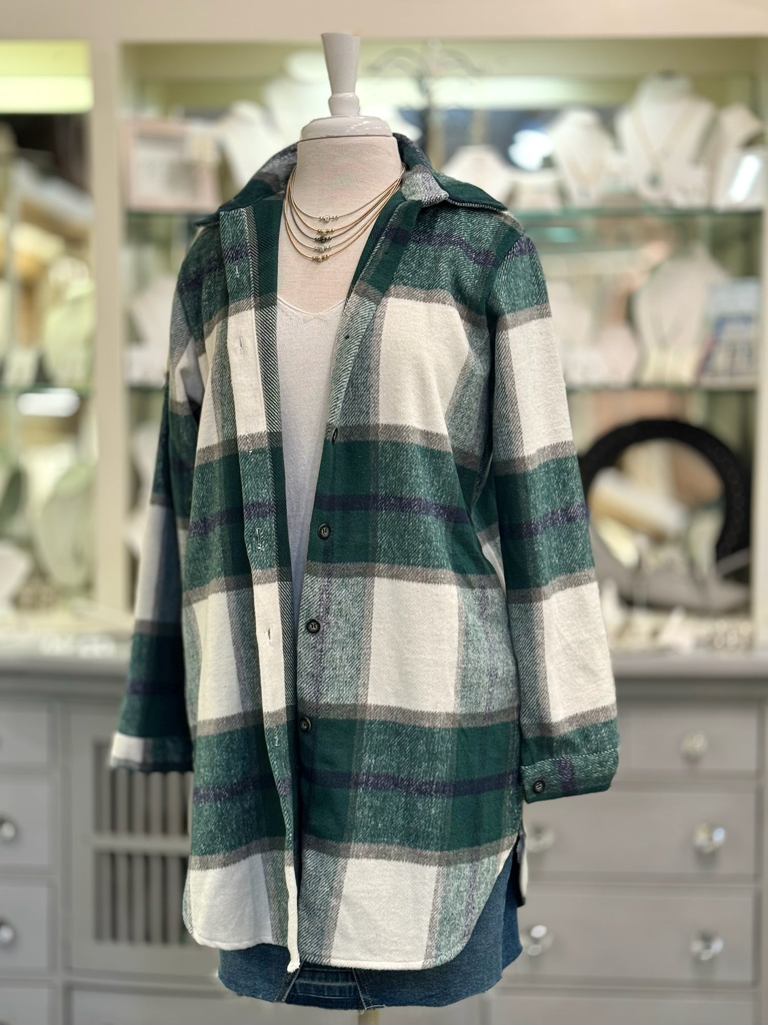 Women’s green plaid button-down shacket with relaxed longline fit.