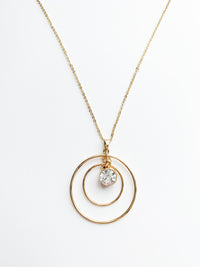 Danielle long gold necklace with 2 halos around a crystal pendent.