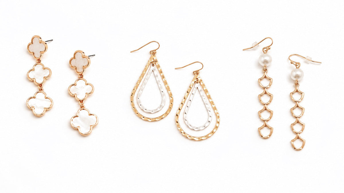 Collection of drop and dangle earrings in gold, silver, and mixed metals, featuring hammered textures, geometric shapes, pearls, and statement designs at Ardor Boutique.