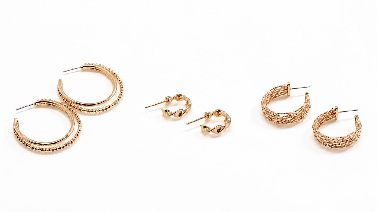 hree pairs of gold-tone hoop earrings featuring large beaded hoops, small twisted hoops, and textured woven hoops on a white background for the Hoop Earrings collection at Ardor Boutique.