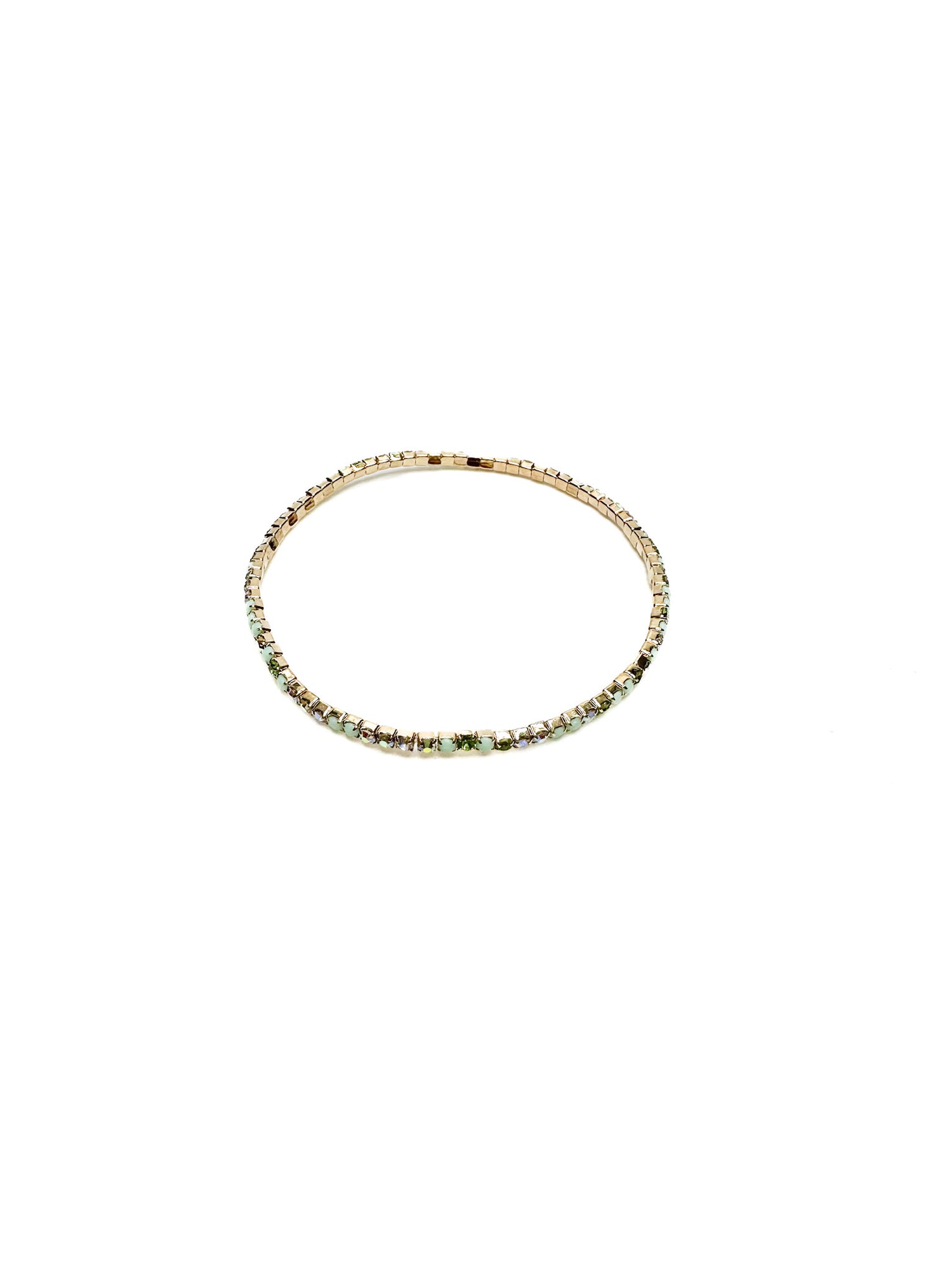 Gold bracelet with green gemstones on a white background