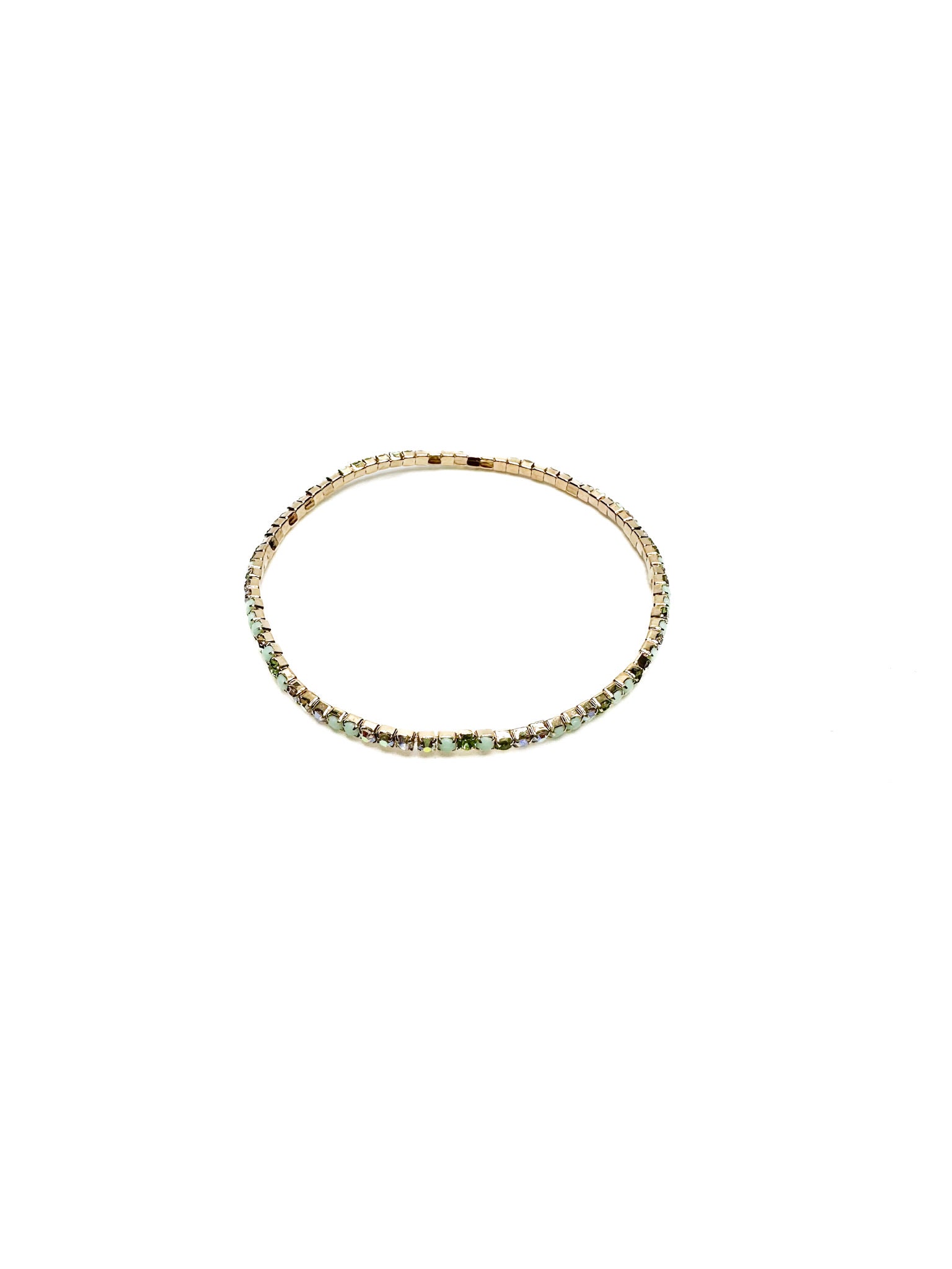 Gold bracelet with green gemstones on a white background