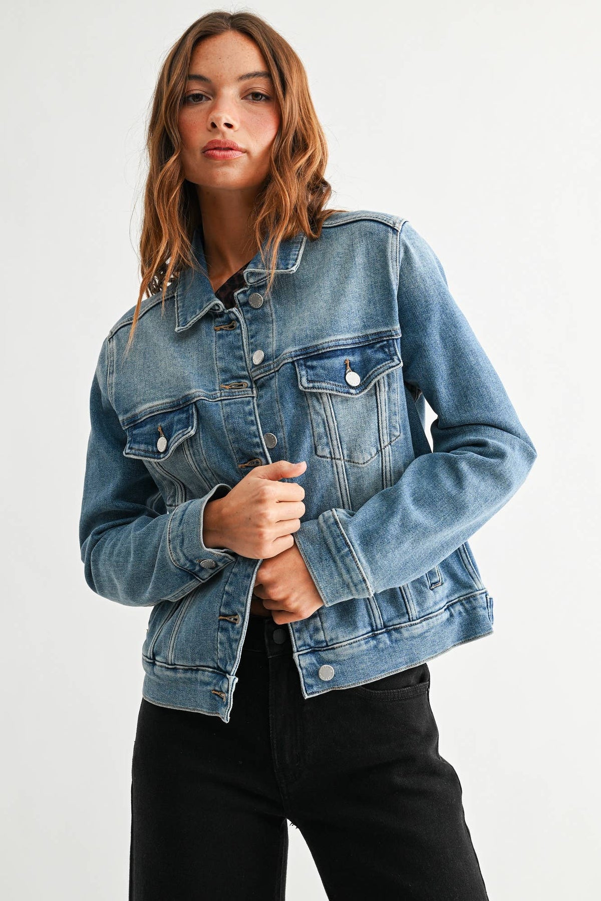 Medium wash denim jacket with button front, chest flap pockets, side pockets and classic collar at Ardor Boutique.