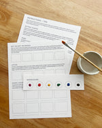 Instructional materials for watercolor painting on a wooden surface with a paintbrush and small container.