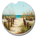 Car coaster with a beach scene featuring a path through sand dunes and ocean view.