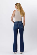 Rear view of denim jeans with classic back pockets and a slight flare at the hem.