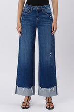 Wide-leg blue jeans with frayed hems on a white background