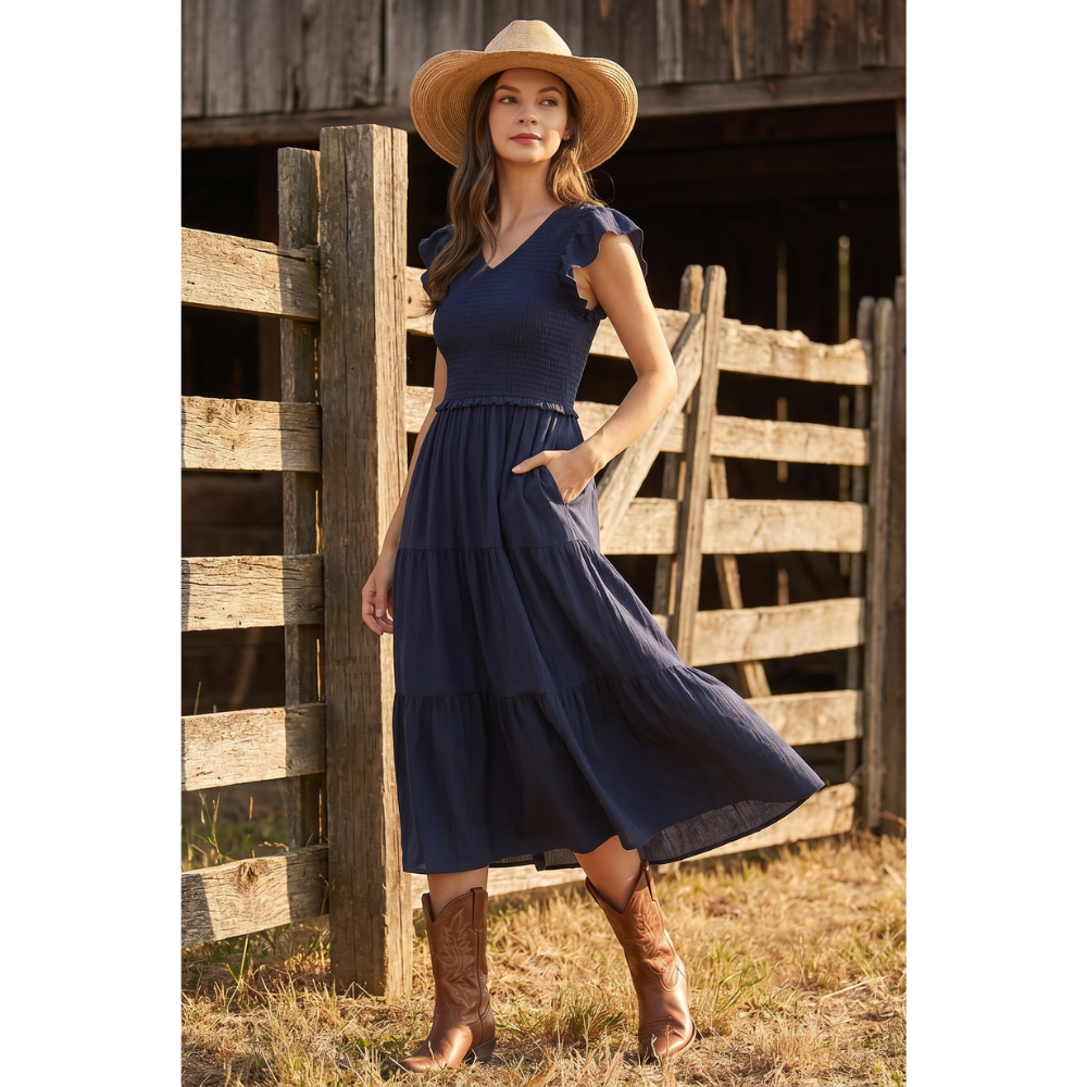 Navy maxi dress with a smocked bodice, V-neckline, ruffle short sleeves and a flowing tiered skirt at Ardor Boutique.