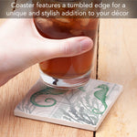 Coaster with seahorse design holding a glass of iced tea on a wooden surface