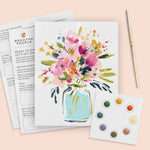 Floral painting kit with a completed artwork of flowers in a jar on a pink background.