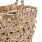 Interior of the Briar Tote in natural woven raffia-style material, featuring a removable natural linen drawstring pouch for added organization and secure storage. The soft linen lining complements the floral crochet exterior while keeping essentials tucked away.