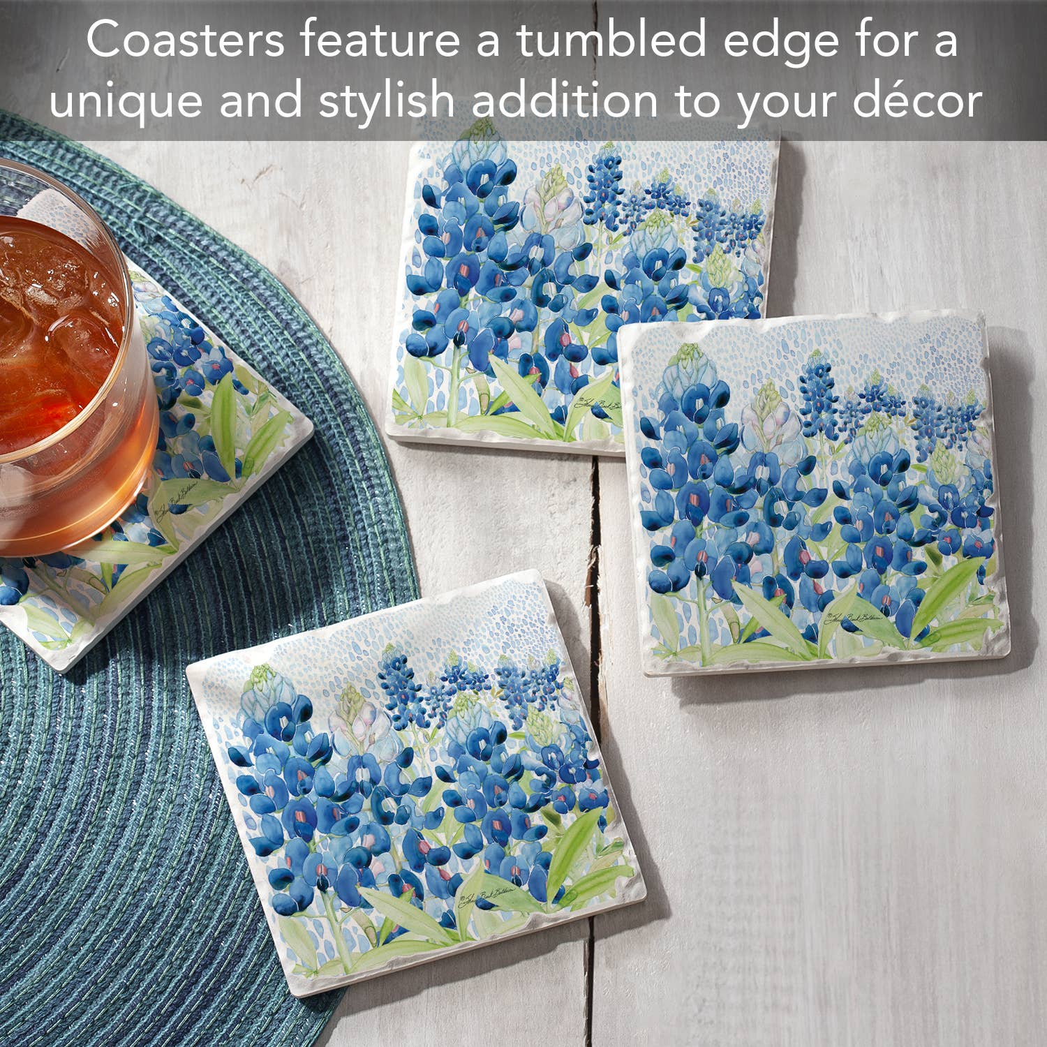 Coasters with blue flower design on a wooden surface with a glass of iced tea.