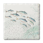 A square ceramic tile or coaster featuring a watercolor-style illustration of a school of fish swimming among pale coral or seaweed on an off-white background.