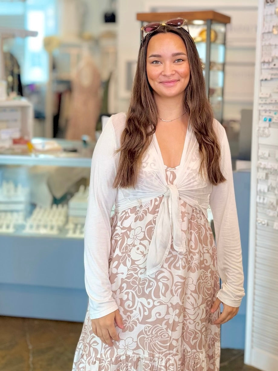 Woman wearing a white lace dress with a blurred store interior background