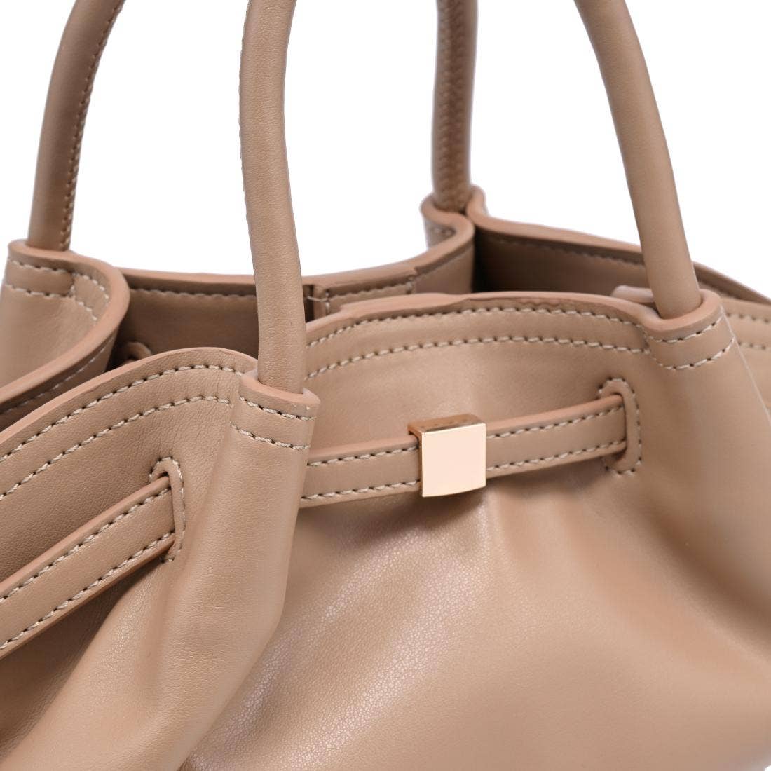 Close-up of the Selena Crossbody showcasing the taupe vegan leather, gathered construction, precise stitching, and gold-tone hardware detail.