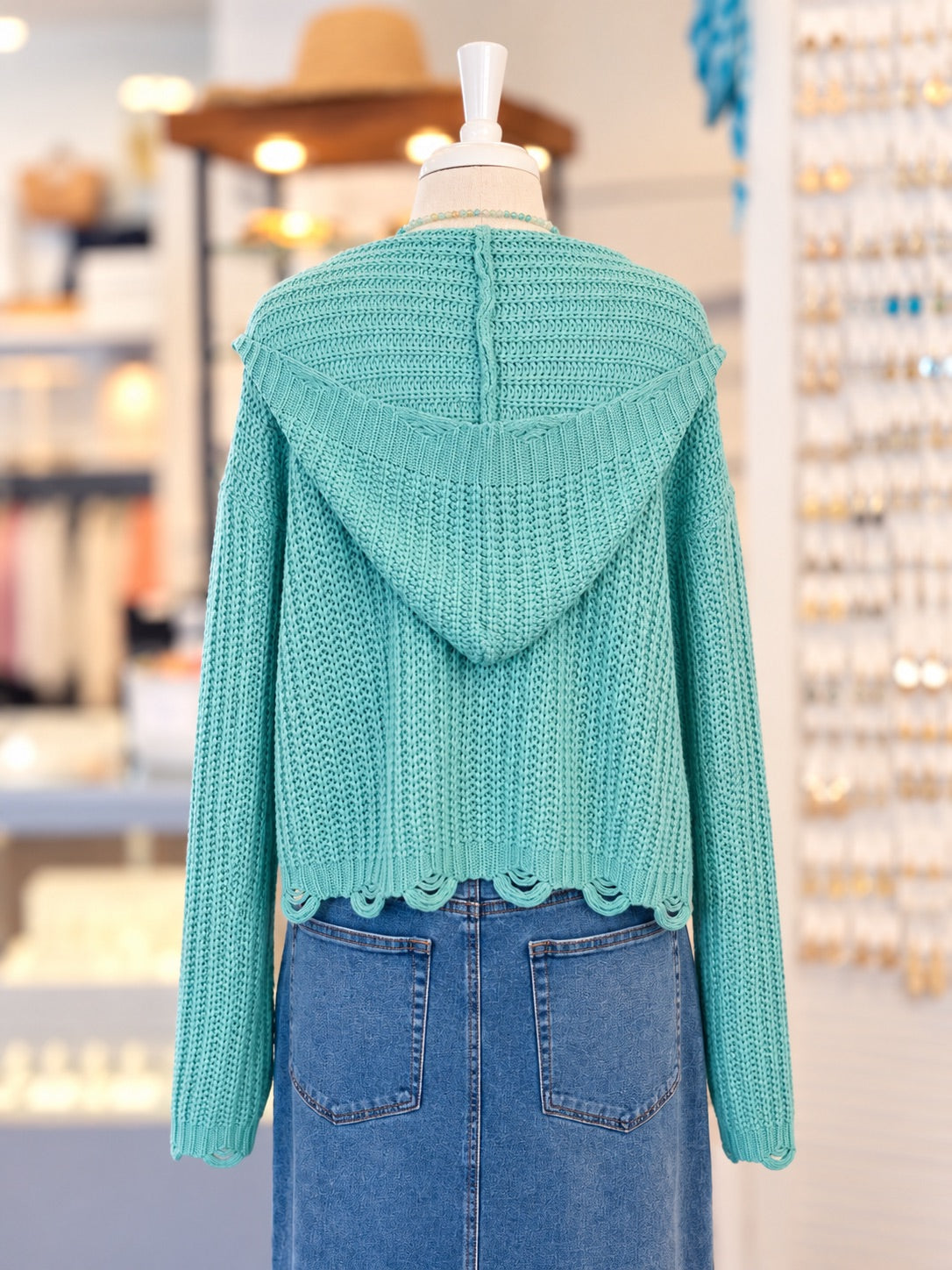 Kennedy Hoodie in teal featuring textured open knit, a full zipper with ring pull, hood with drawstrings, and cropped scalloped hem, styled with denim at Ardor Boutique.