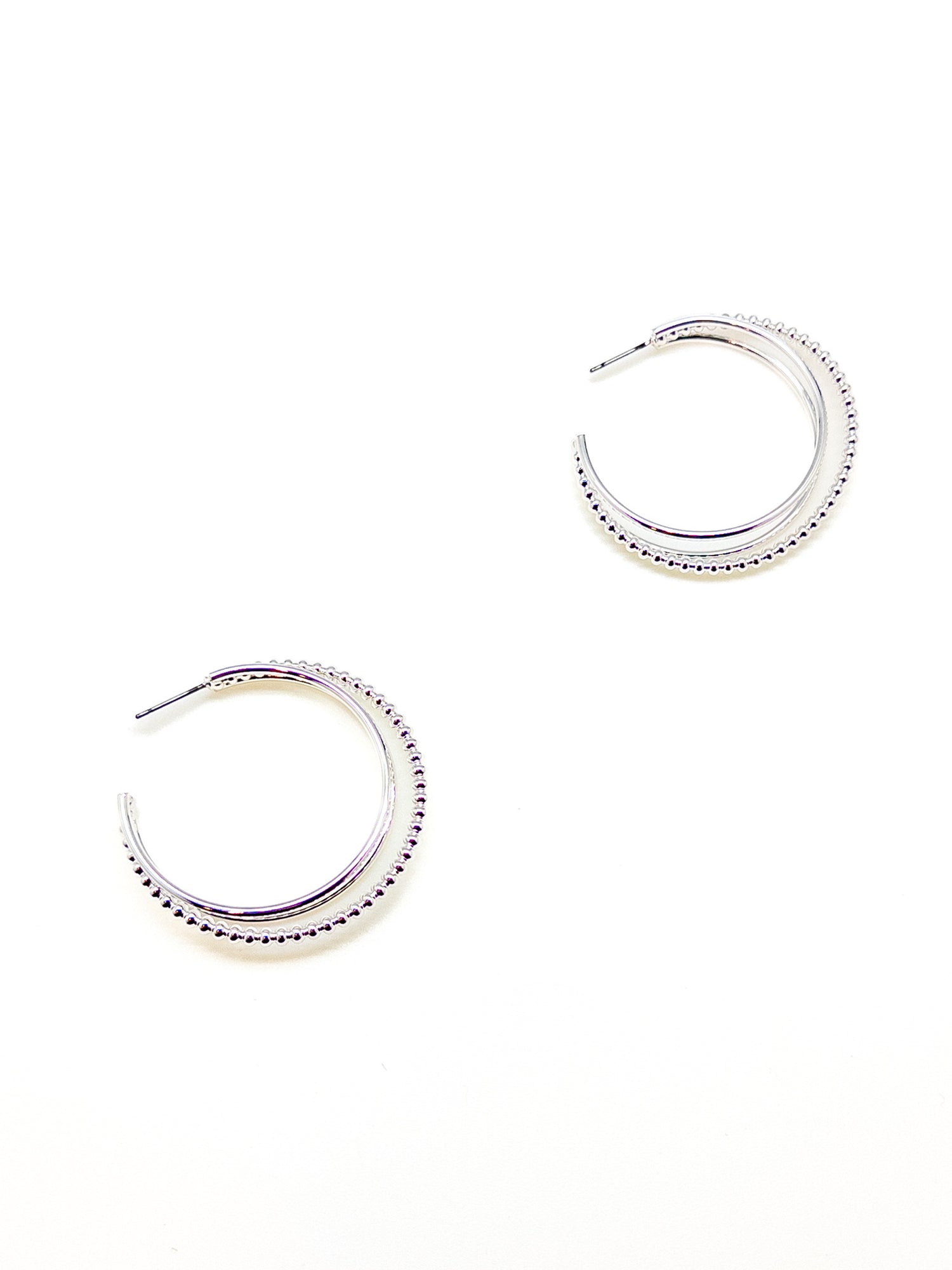 Pair of silver hoop earrings on a white background
