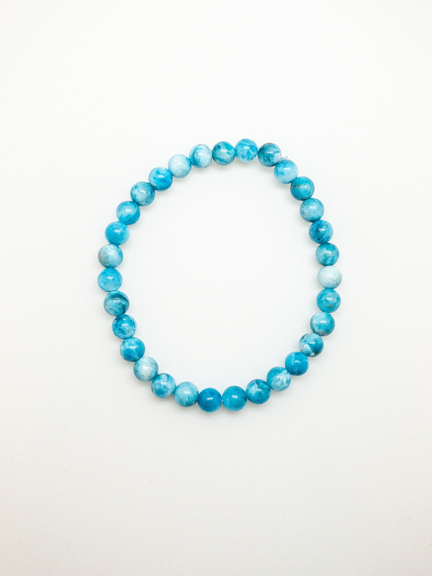 A bracelet with a mix of blue and clear beads on a white background