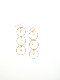 Christina earrings. 3 gold circles with pearl in center of each