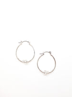 Silver Kelly hoop earrings with a knot detail in the bottom center of earring
